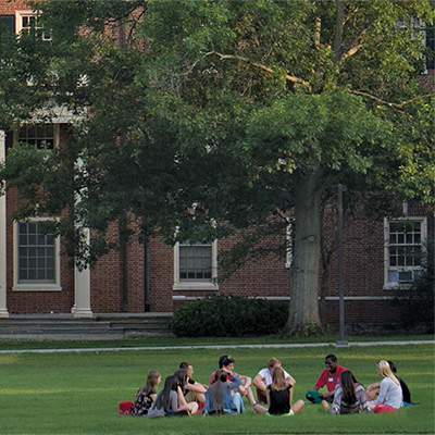 students sitting in a circle outside on a summer day